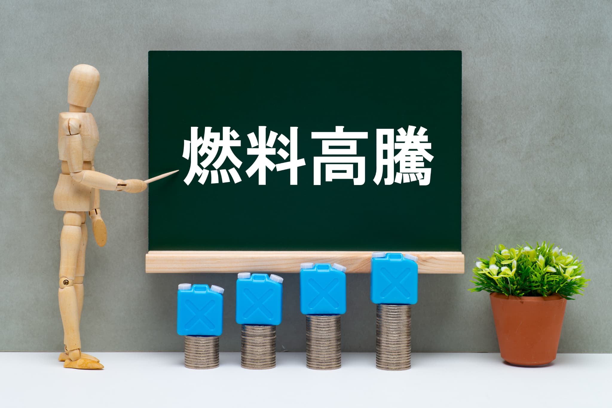 積み上げられたコインとポリタンクと燃料高騰のイメージ